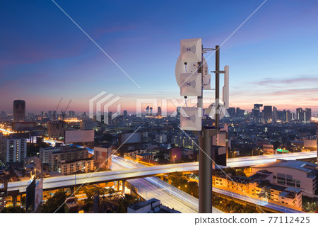 Telecommunication tower with 5G cellular network antenna on night city background 77112425