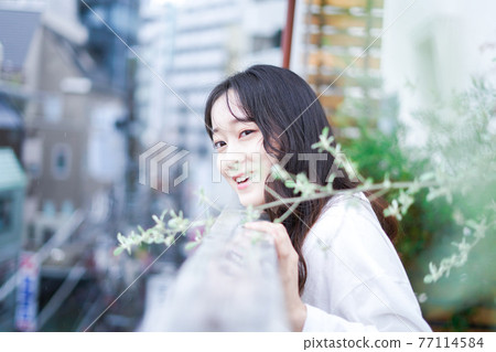 檢查外面天氣的年輕女人 77114584