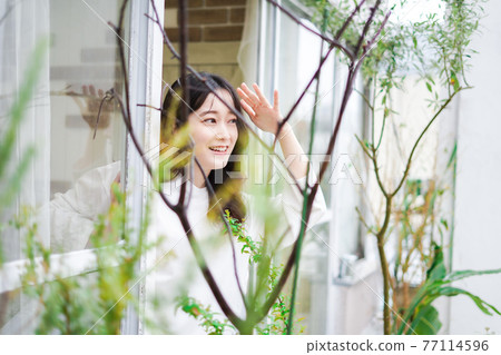 檢查外面天氣的年輕女人 77114596