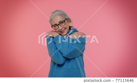 Mature old granny grandmother spread hands and give hug to you, pleasant expression, love feelings 77115646