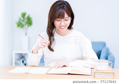 戴眼鏡在客廳學習的年輕女子 戴眼鏡在客廳學習的年輕女子 77117643