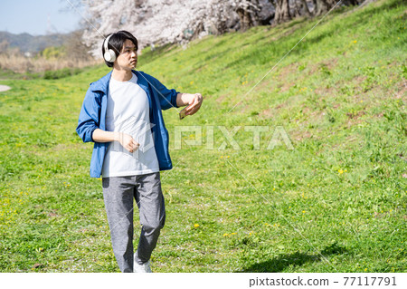 一個男人一邊聽音樂一邊享受散步 77117791