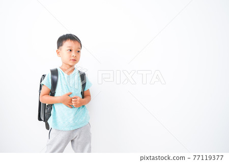Boy carrying a school bag Boy carrying a school bag 77119377
