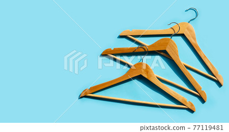 Wooden clothes hangers on blue background 77119481
