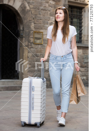 young tourist taking walk in city with the travel bag young tourist taking walk in city with the travel bag 77120793