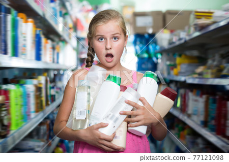 Girl holding shampoo and shower gel Girl holding shampoo and shower gel 77121098