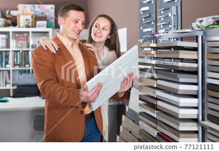 joyful family couple looking at kitchen facade in furniture workshop joyful family couple looking at kitchen facade in furniture workshop 77121111