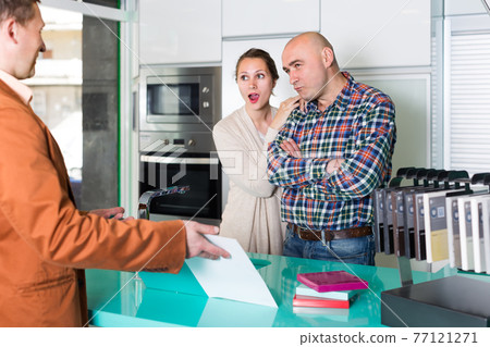 Couple making claims at kitchen store Couple making claims at kitchen store 77121271