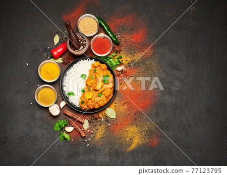 Plate of Traditional Chicken Curry and set of spices on dark concrete background Plate of Traditional Chicken Curry and set of spices on dark concrete background 77123795