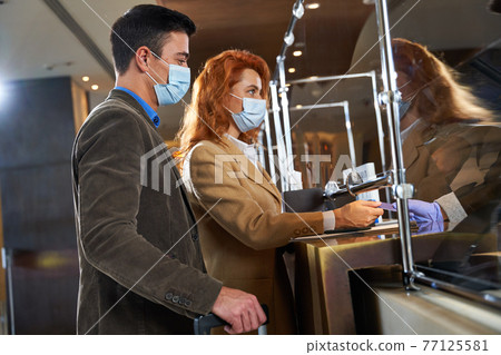 Tourists paying for the room they have booked online 77125581