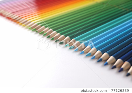Many multicolored pencils lying in color of rainbow on white background closeup 77126289
