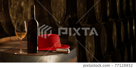 Bottle and glass of fine white sherry wine in winery with typical Jerez with Venetian and red hat  background banner 77128932