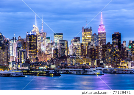 West New York City midtown Manhattan skyline view from Boulevard East Old Glory Park over Hudson River at dusk. 77129471