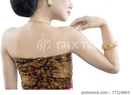 Rear view of Asian woman with Java traditional dance costume Rear view of Asian woman with Java traditional dance costume 77129665