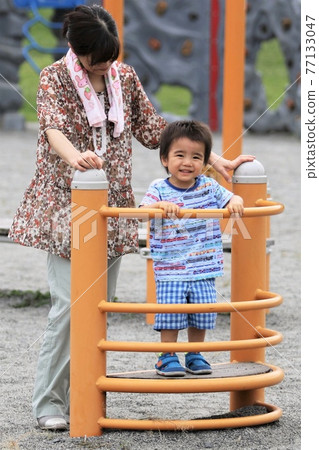 3-year-old boy playing with grandma in the park 77133047