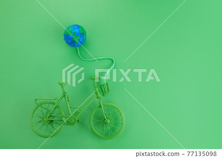 World bicycle day concept. Green bicykle with globe on green background. 3 june. 77135098