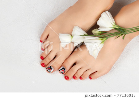 Manicure, pedicure beauty salon concept. Womans feet on gray background Manicure, pedicure beauty salon concept. Womans feet on gray background 77136013