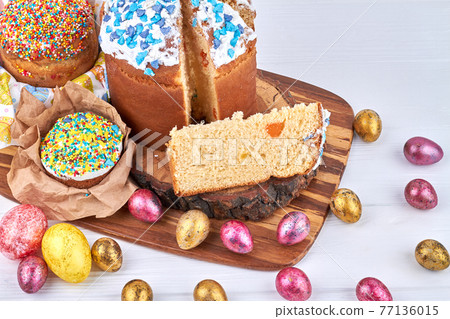 Easter cakes with colorful topping on a wooden board. 77136015