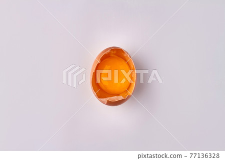 Raw cracked chicken egg with yolk. 77136328