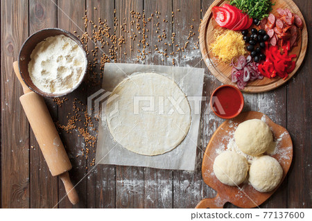 Pizza dough with ingredients on wood table Pizza dough with ingredients on wood table 77137600