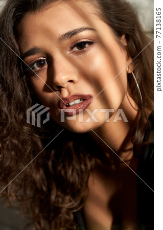 Brunette girl posing near white brick wall. 77138165