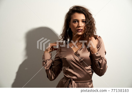 Female model posing near white wall. Female model posing near white wall. 77138183