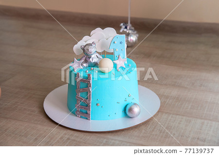 Birthday cake with light blue mirror glaze. Chocolate decor and number one. Birthday cake with light blue mirror glaze. Chocolate decor and number one. 77139737