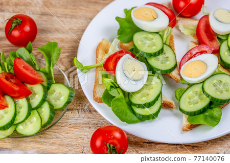 Fried bread toasts with vegetable and egg slices and salad Fried bread toasts with vegetable and egg slices and salad 77140076