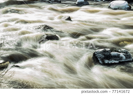 Long exposure photo. Rough river Jokelanjoki and stones in water, Kouvola, Finland. 77141672
