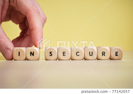 Concept secure and insecure on wooden cubes. 77142057