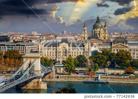 View of the tower Budapest chain Secheni Bridge rooftops of the historic Old Town of Budapest Hungary from a height. View of the tower Budapest chain Secheni Bridge rooftops of the historic Old Town of Budapest Hungary from a height. 77142636