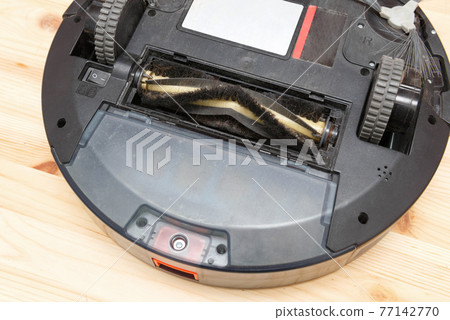 Replacement of the brush of a robot vacuum cleaner with hair, close-up. 77142770