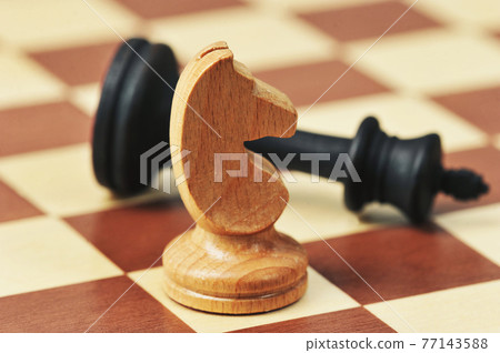 wooden chess pieces on a chessboard wooden chess pieces on a chessboard 77143588