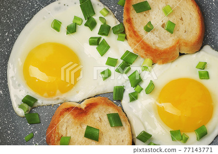 breakfast with fried eggs and green onions and baguette breakfast with fried eggs and green onions and baguette 77143771