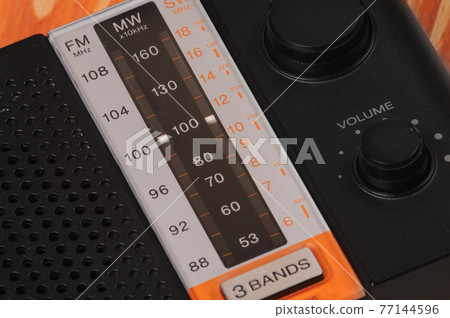 Vintage radio for listening to radio programs on a wooden background 77144596