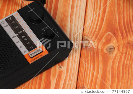 Vintage radio for listening to radio programs on a wooden background 77144597