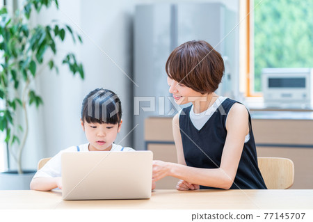 一位母親看著孩子在網上學習。 一位母親看著孩子在網上學習。 77145707
