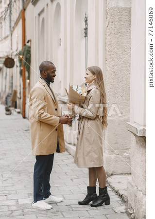 Mixed couple spenting time together in a spring city Mixed couple spenting time together in a spring city 77146069