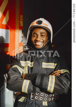 Portrait of a firefighter standing in front of a fire engine Portrait of a firefighter standing in front of a fire engine 77146193