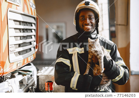 Portrait of a firefighter standing in front of a fire engine Portrait of a firefighter standing in front of a fire engine 77146203