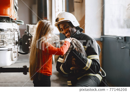Portrait of a firefighter standing in front of a fire engine 77146208