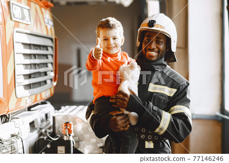 Portrait of a firefighter standing in front of a fire engine 77146246