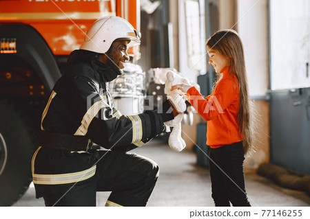 Portrait of a firefighter standing in front of a fire engine Portrait of a firefighter standing in front of a fire engine 77146255