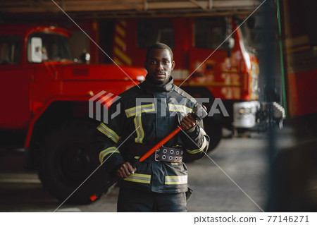 Portrait of a firefighter standing in front of a fire engine Portrait of a firefighter standing in front of a fire engine 77146271
