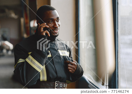 Portrait of a firefighter standing in front of a fire engine Portrait of a firefighter standing in front of a fire engine 77146274