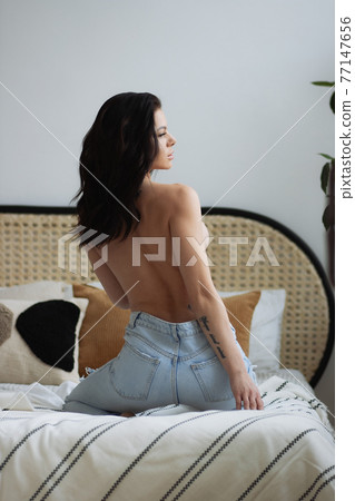 Topless woman touching breast in bedroom Topless woman touching breast in bedroom 77147656