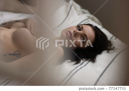 Sensual woman touching naked breast in bedroom 77147731