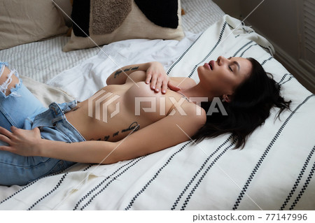 Sensual woman touching naked breast in bedroom Sensual woman touching naked breast in bedroom 77147996