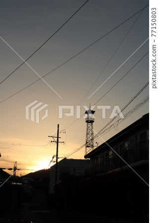 Silhouette of the fire lookout tower at dusk 77150803