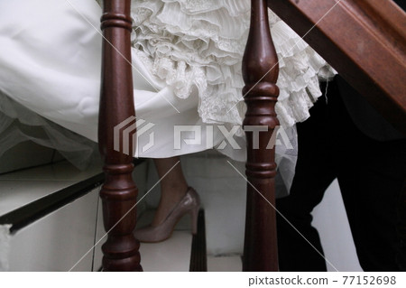 The bride in purple-gray shoes goes upstairs 77152698